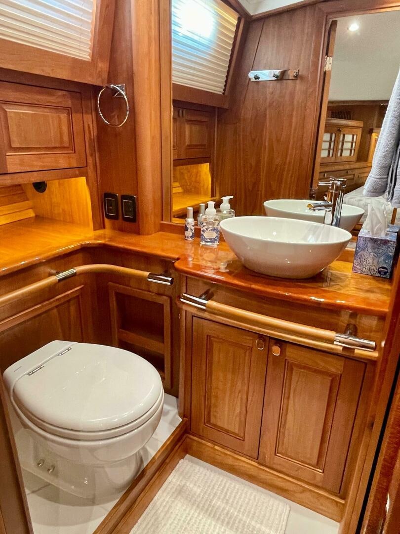 a bathroom with a toilet sink and a mirror aboard WHIRL AWAY Yacht for Sale