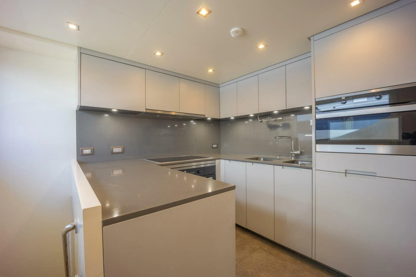 a kitchen with white cabinets aboard PHOENIX Yacht for Sale