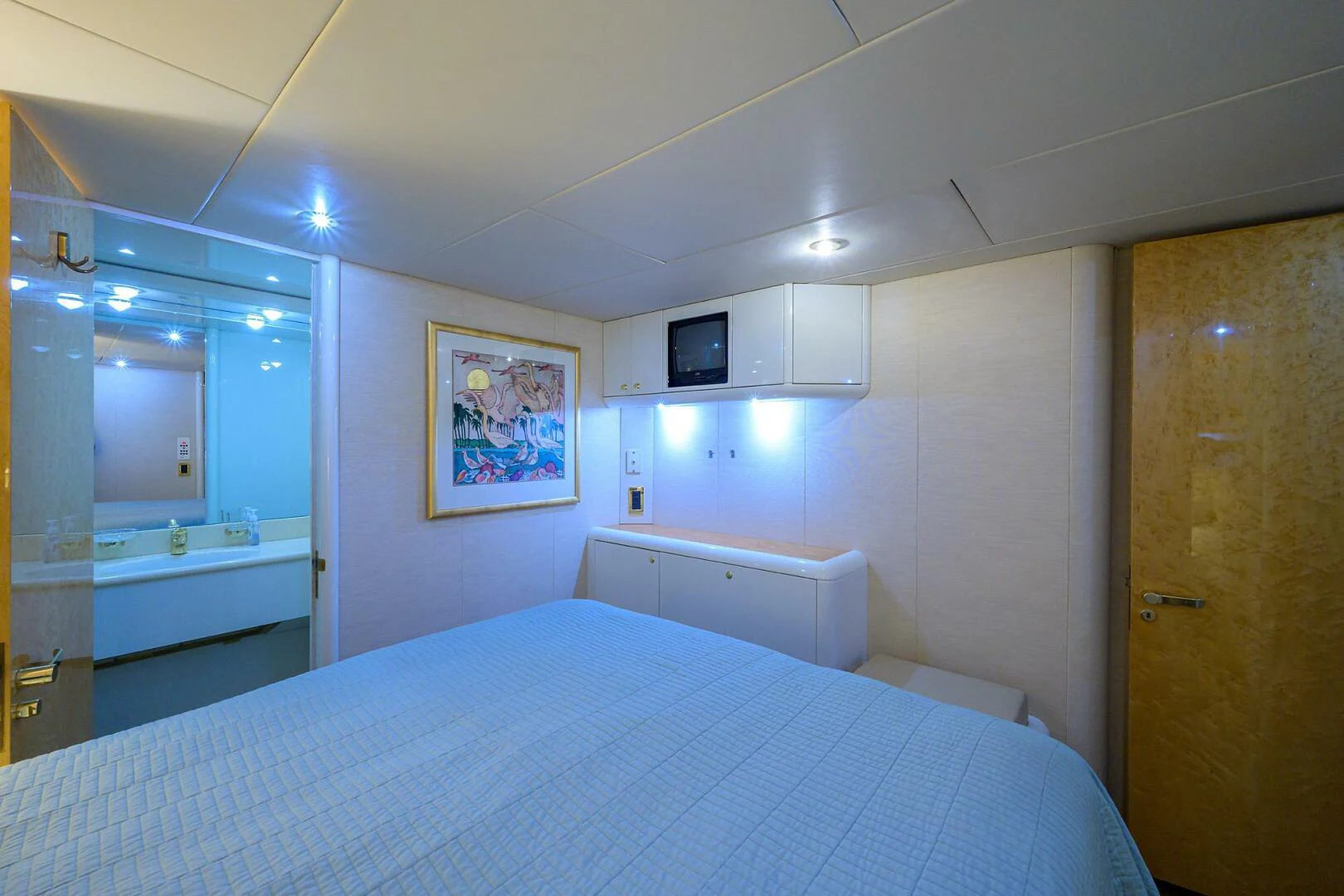 a large bedroom with a large blue bed spread aboard LOST TEXAN Yacht for Sale