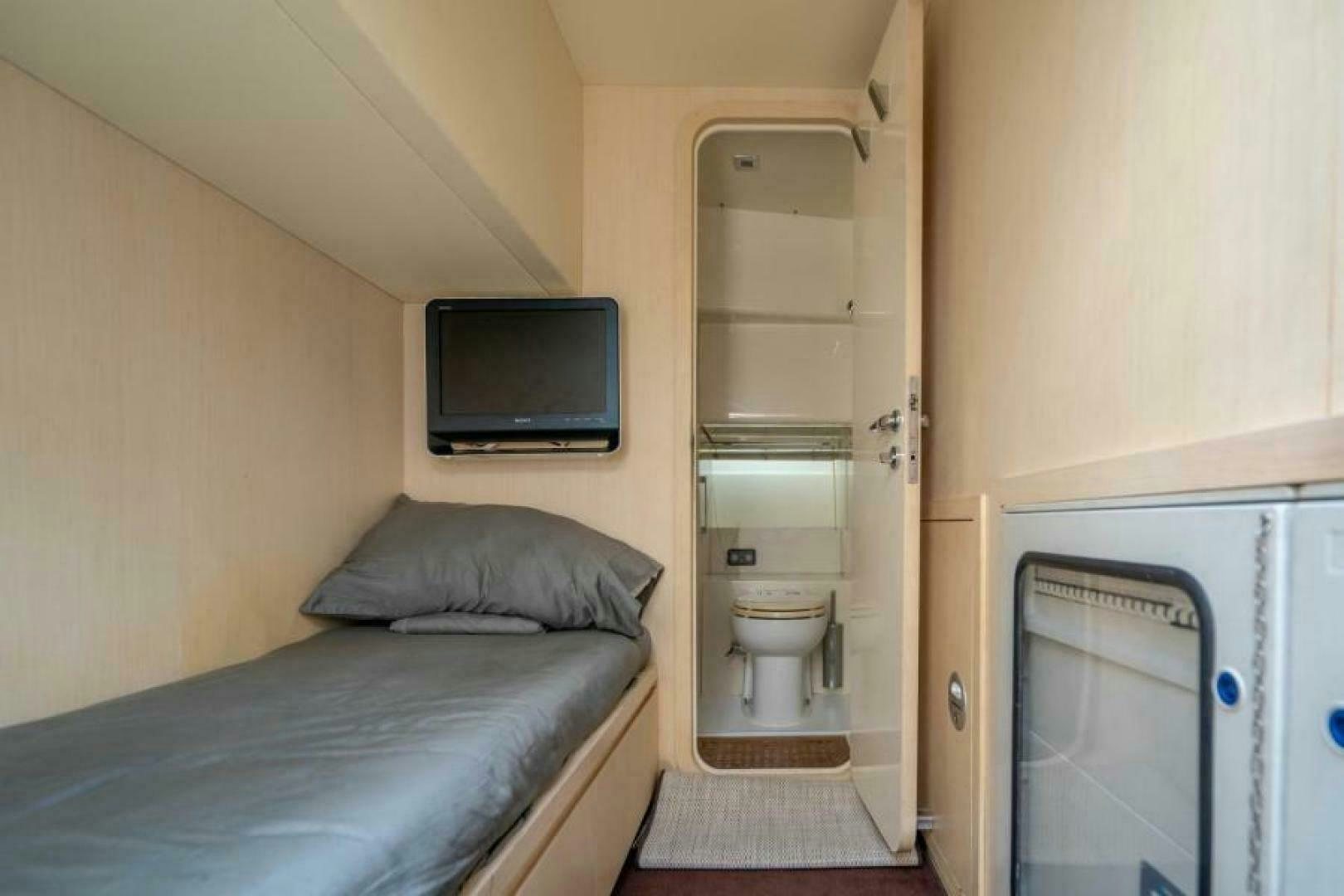 a small bedroom with a bed and a television aboard EQUINOX Yacht for Sale