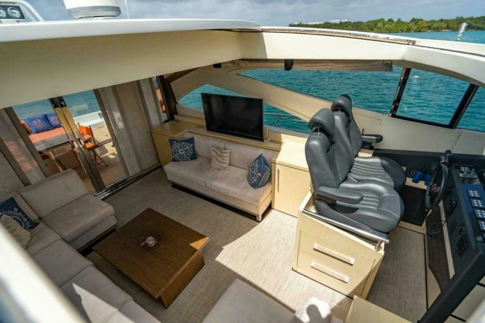 a room with a couch and a television aboard EQUINOX Yacht for Sale