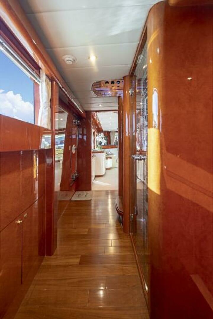 a hallway with a wood floor and a door with a window aboard SIXTY SIX Yacht for Sale