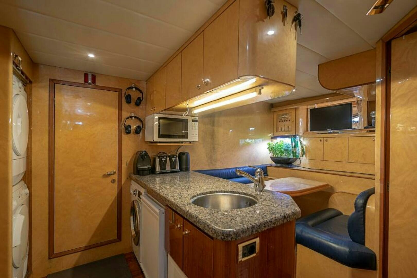 a kitchen with wooden cabinets aboard SIXTY SIX Yacht for Sale
