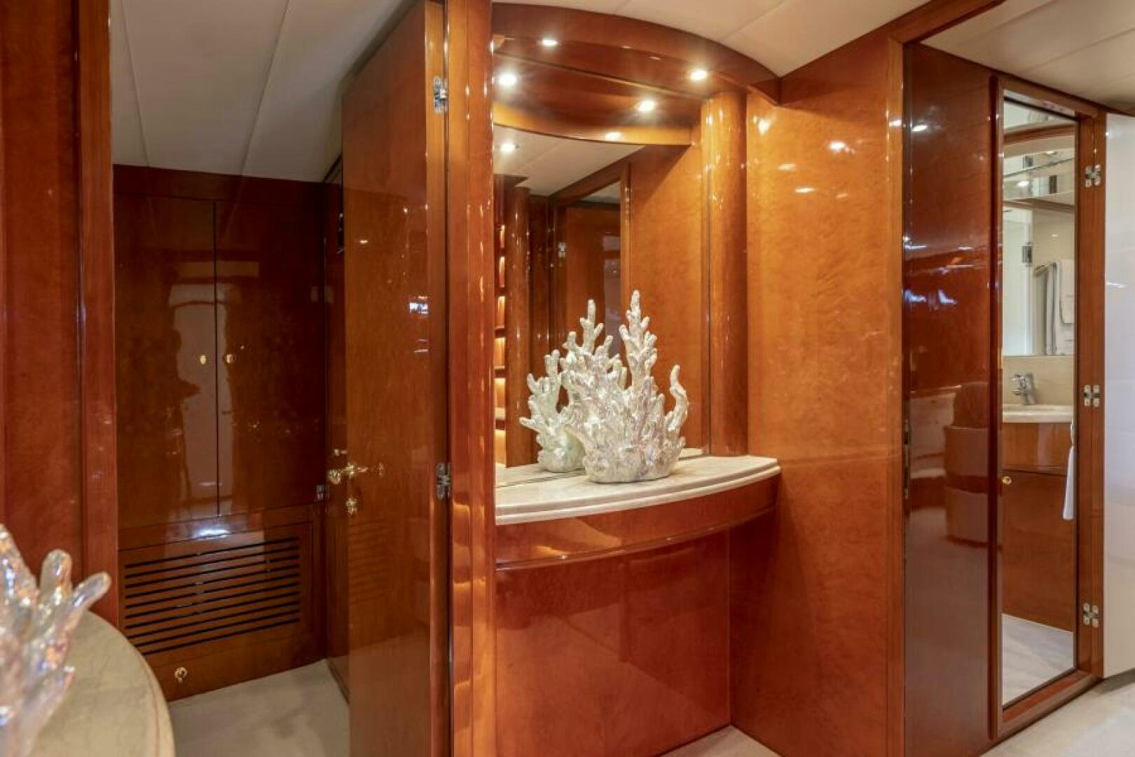 a room with a mirror and a vase of flowers aboard SIXTY SIX Yacht for Sale