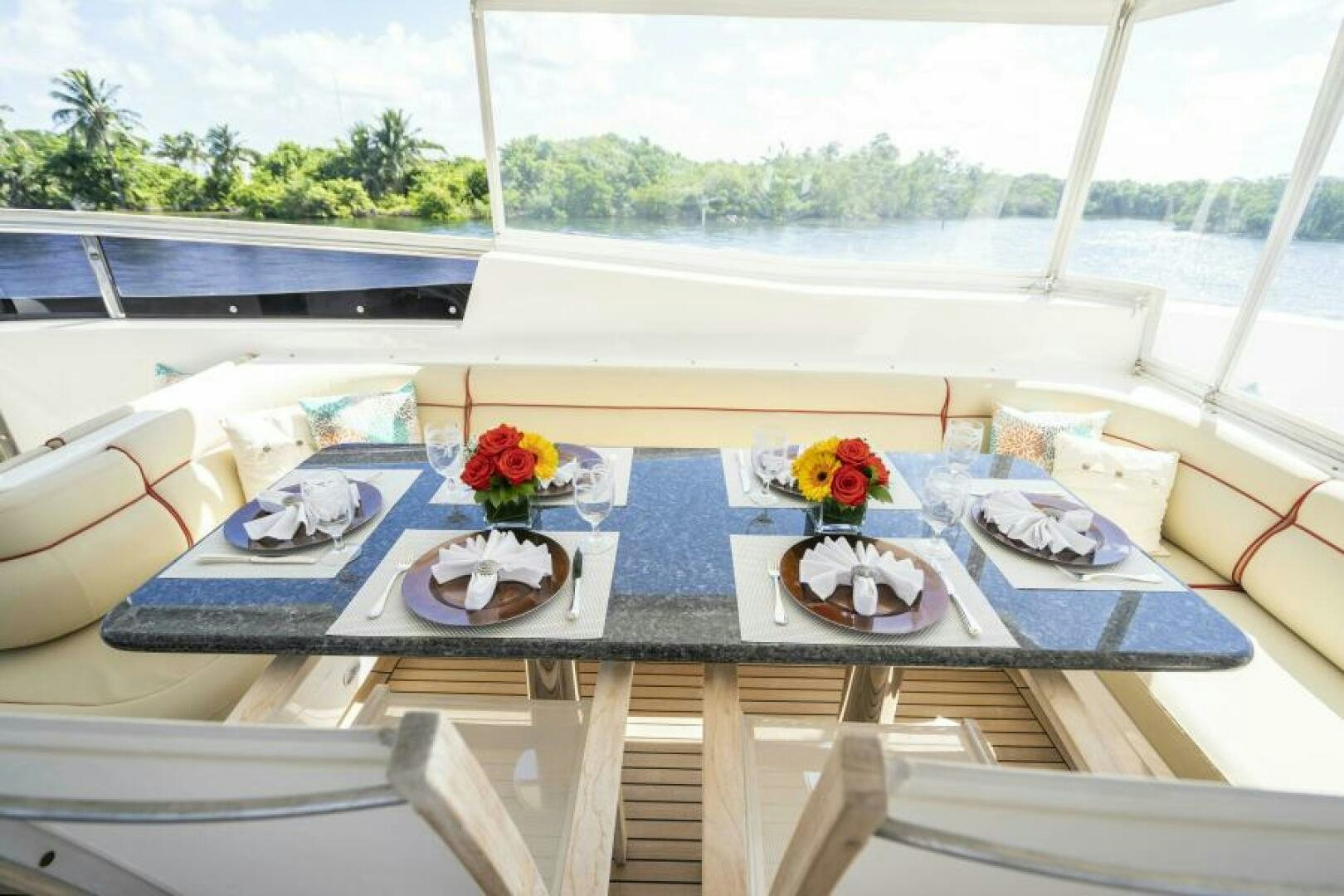 a table with plates and flowers on it aboard SIXTY SIX Yacht for Sale