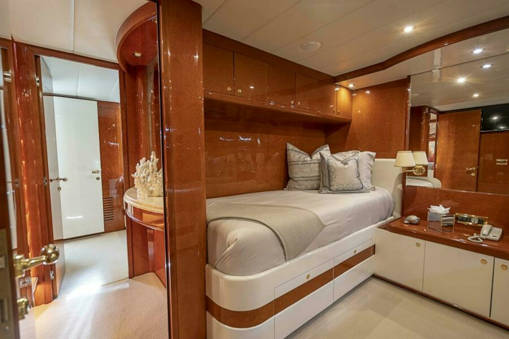 a bedroom with a bed and a mirror aboard SIXTY SIX Yacht for Sale