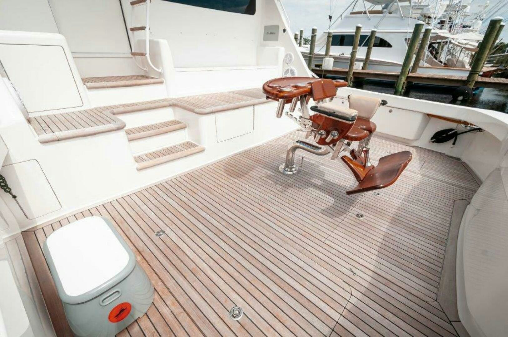 a white chair on a wooden floor aboard BAREFOOT DRIVE Yacht for Sale