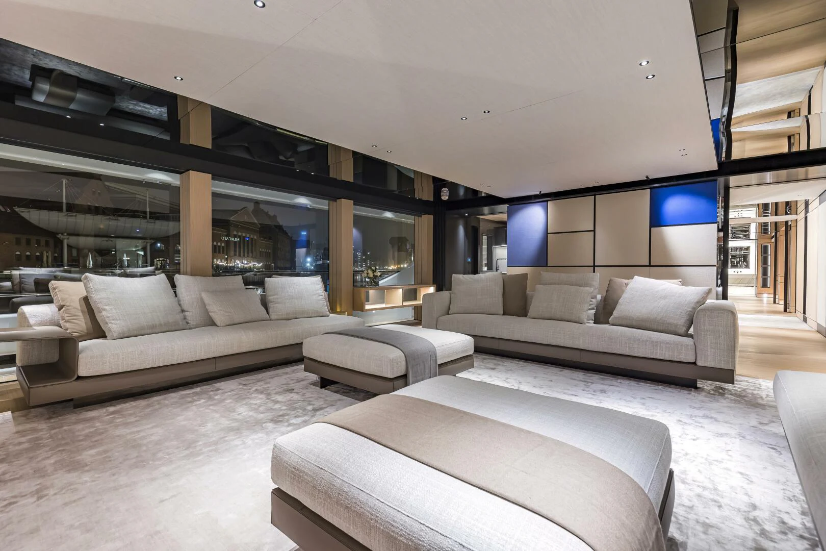 a modern living room with a large white couch and a large window aboard CONRAD C144S HULL 4 Yacht for Sale