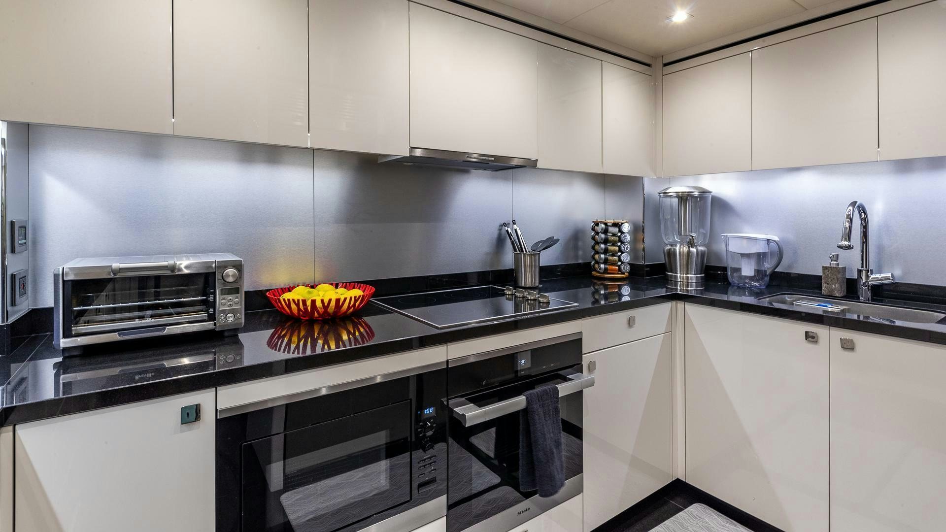 a kitchen with white cabinets aboard MIRRACLE Yacht for Sale