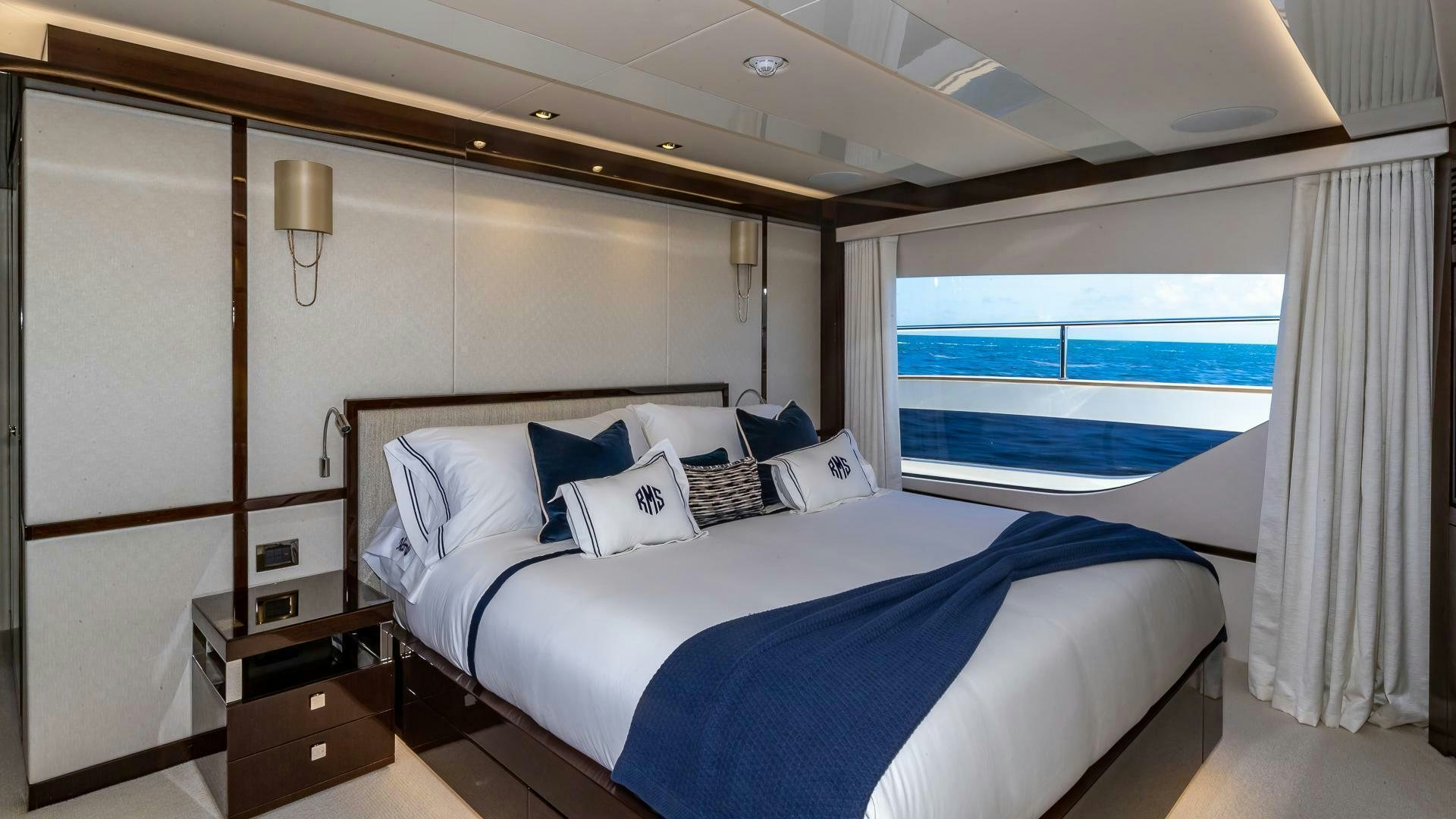 a bed with a blue and white bed spread aboard MIRRACLE Yacht for Sale
