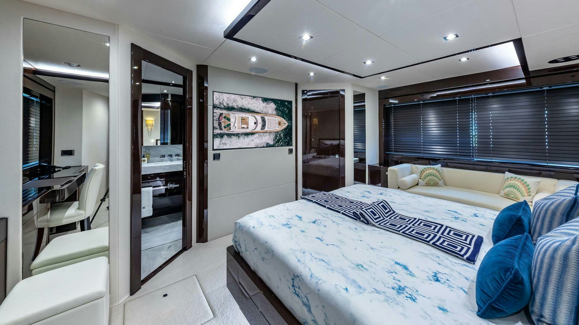 a bedroom with a bed and a desk aboard MIRRACLE Yacht for Sale