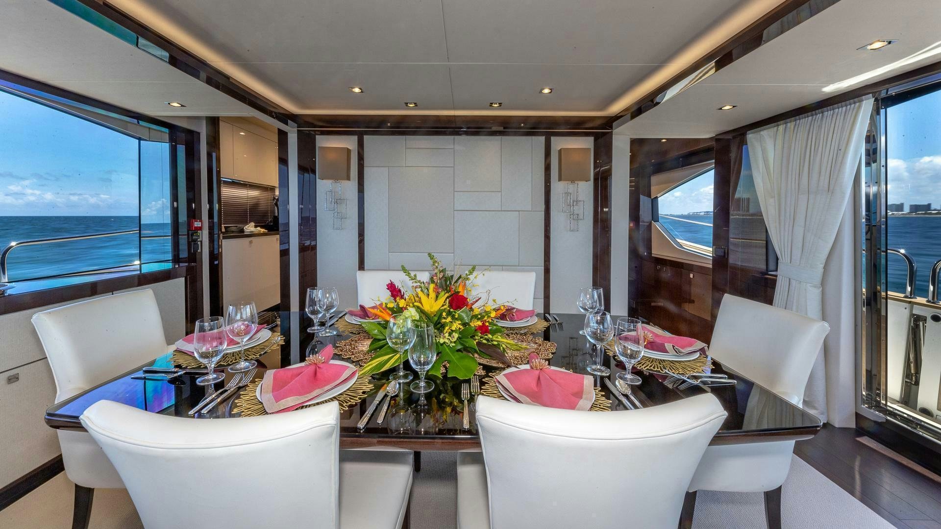 a room with a table chairs and flowers in it aboard MIRRACLE Yacht for Sale
