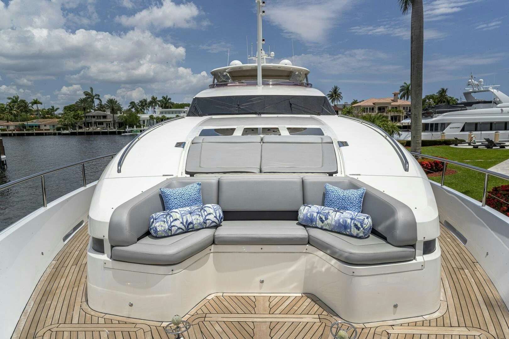 a white car with blue pillows on a deck by water aboard BEACHFRONT II Yacht for Sale