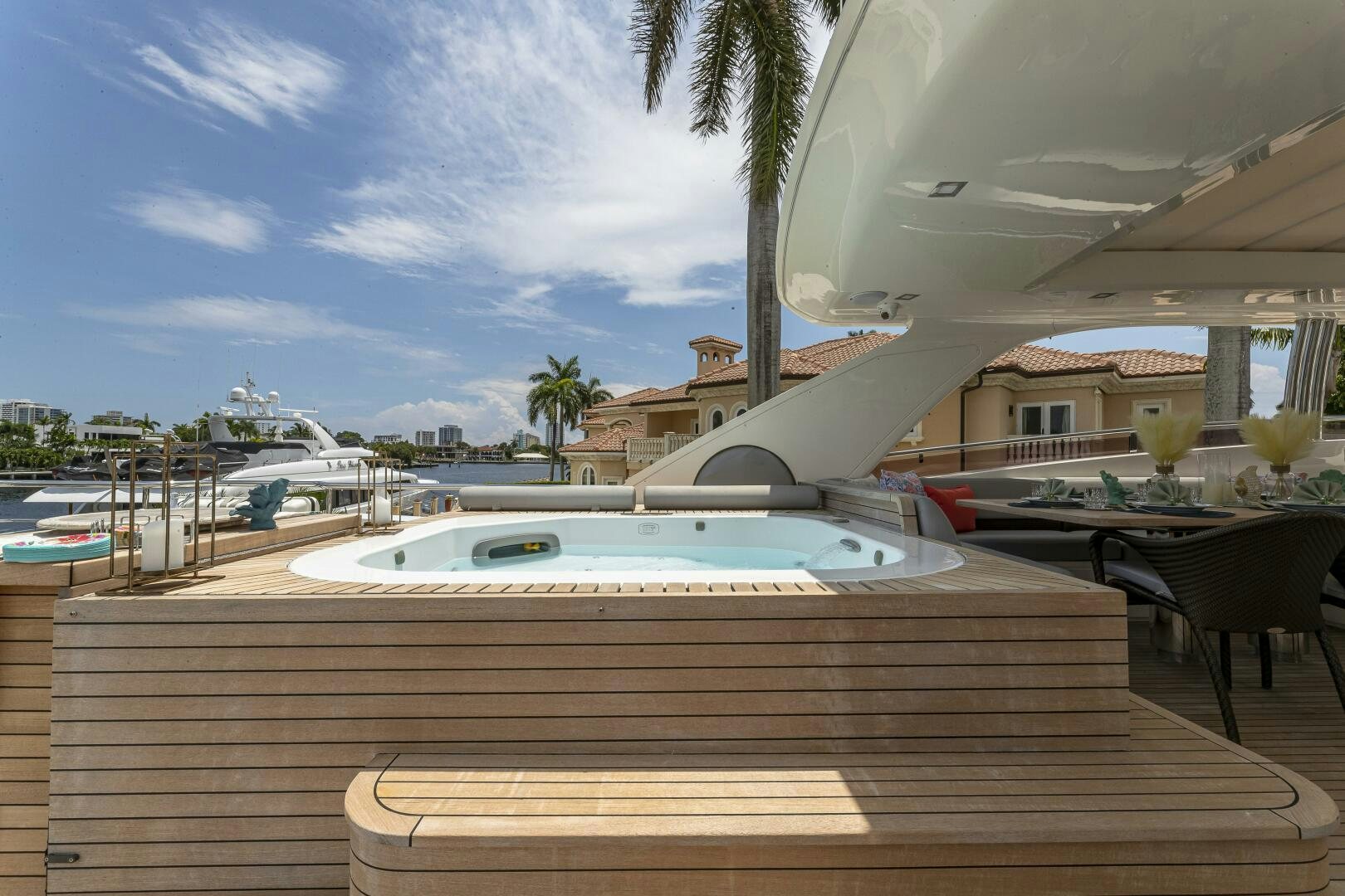 a pool and a deck with a building in the background aboard BEACHFRONT II Yacht for Sale