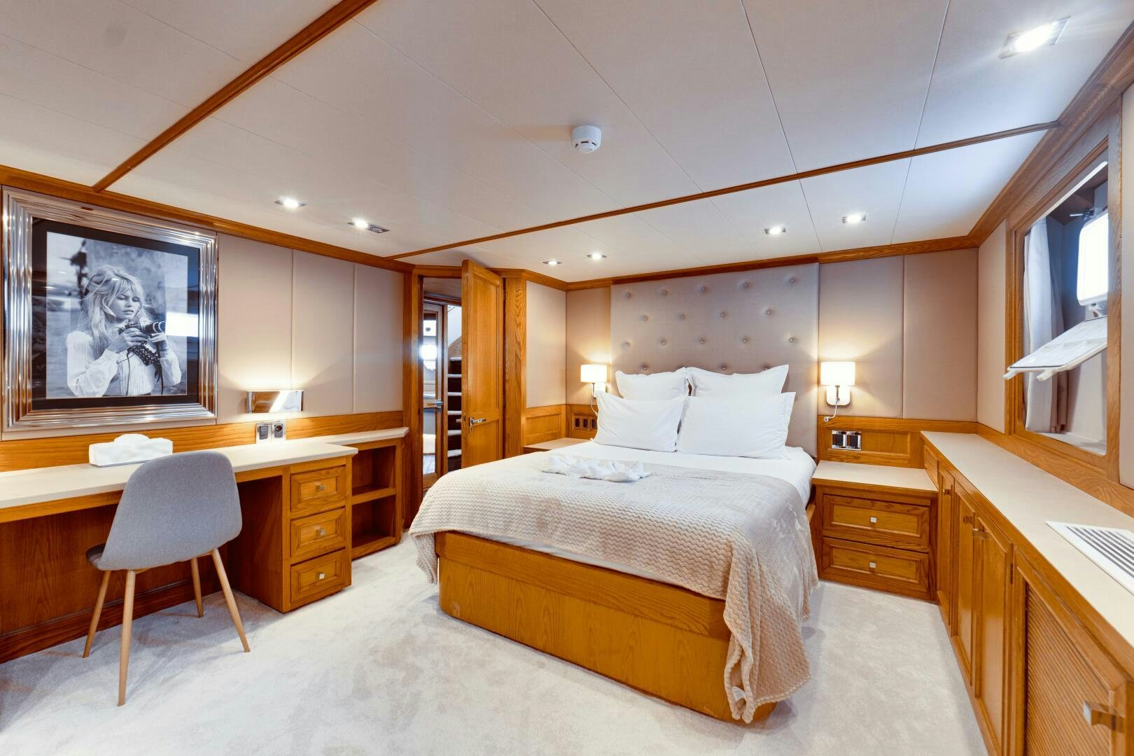 a bedroom with a bed and desk aboard EVA Yacht for Sale