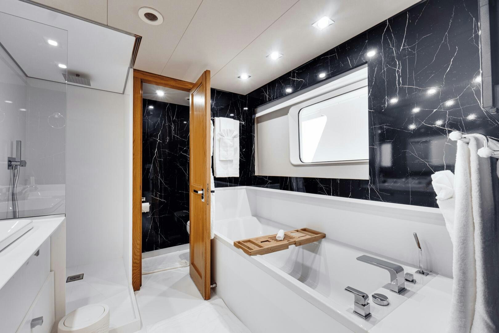 a bathroom with a tub sink and mirror aboard EVA Yacht for Sale