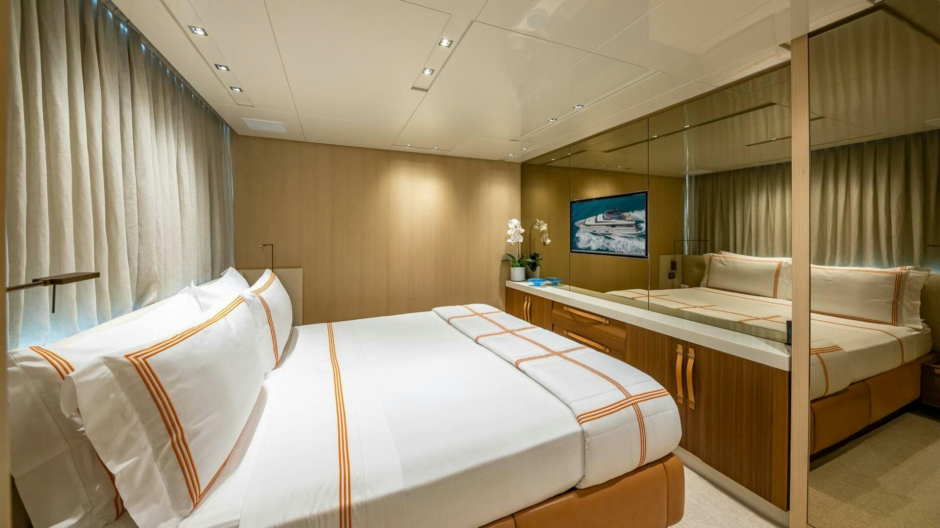 a room with a bed and a tv on the wall aboard WOMBAT Yacht for Sale
