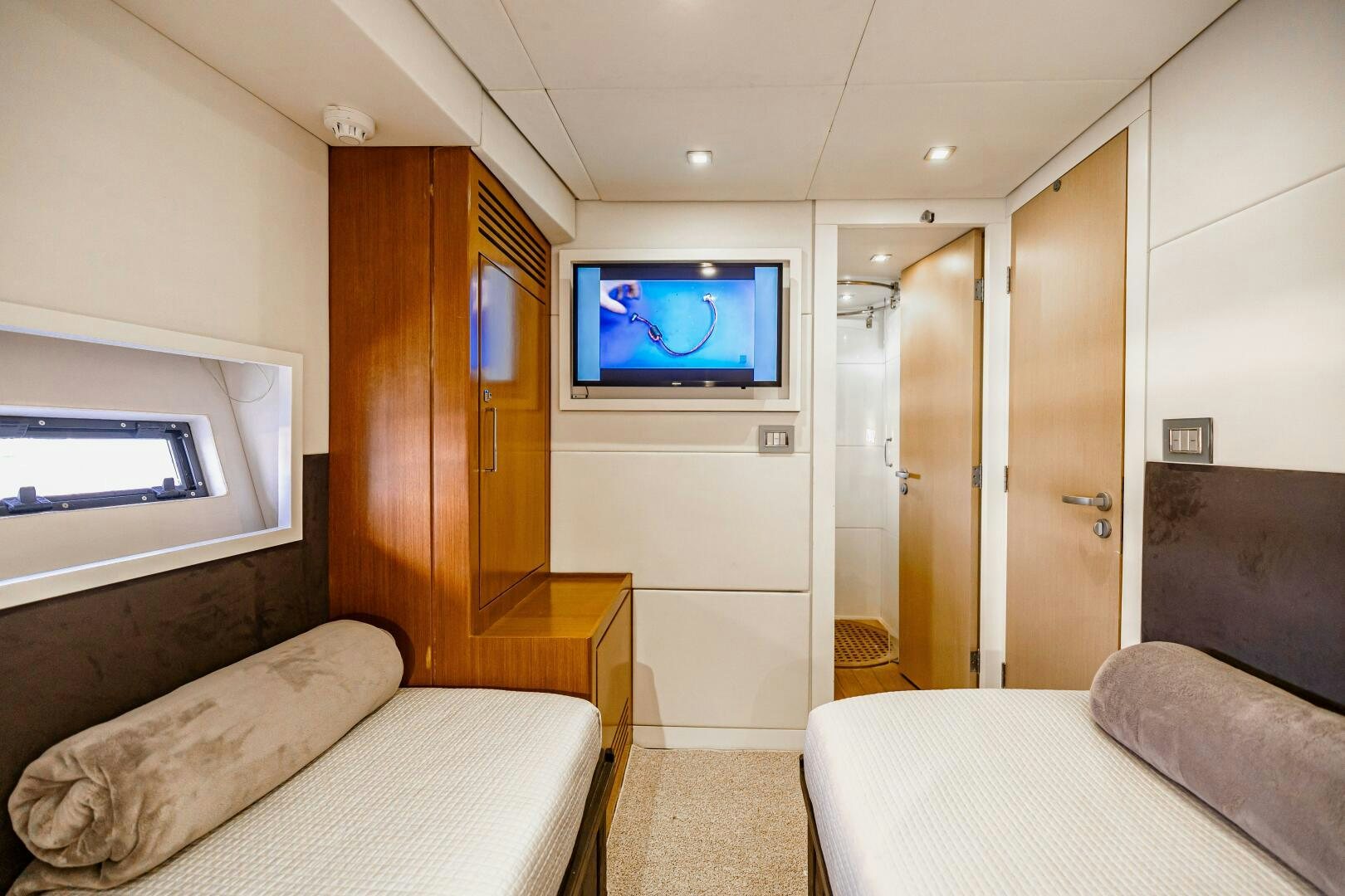 a bedroom with a tv on the wall aboard VELOCE II Yacht for Sale