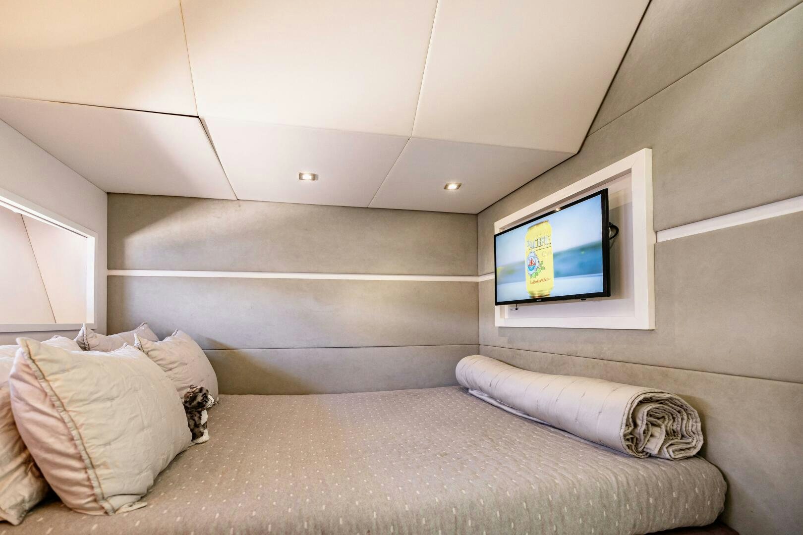 a bed with a television on the wall aboard VELOCE II Yacht for Sale