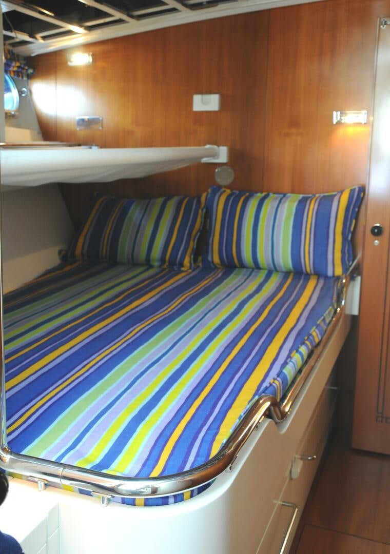 a bed with blue and white striped sheets aboard BILLY BUDD Yacht for Sale