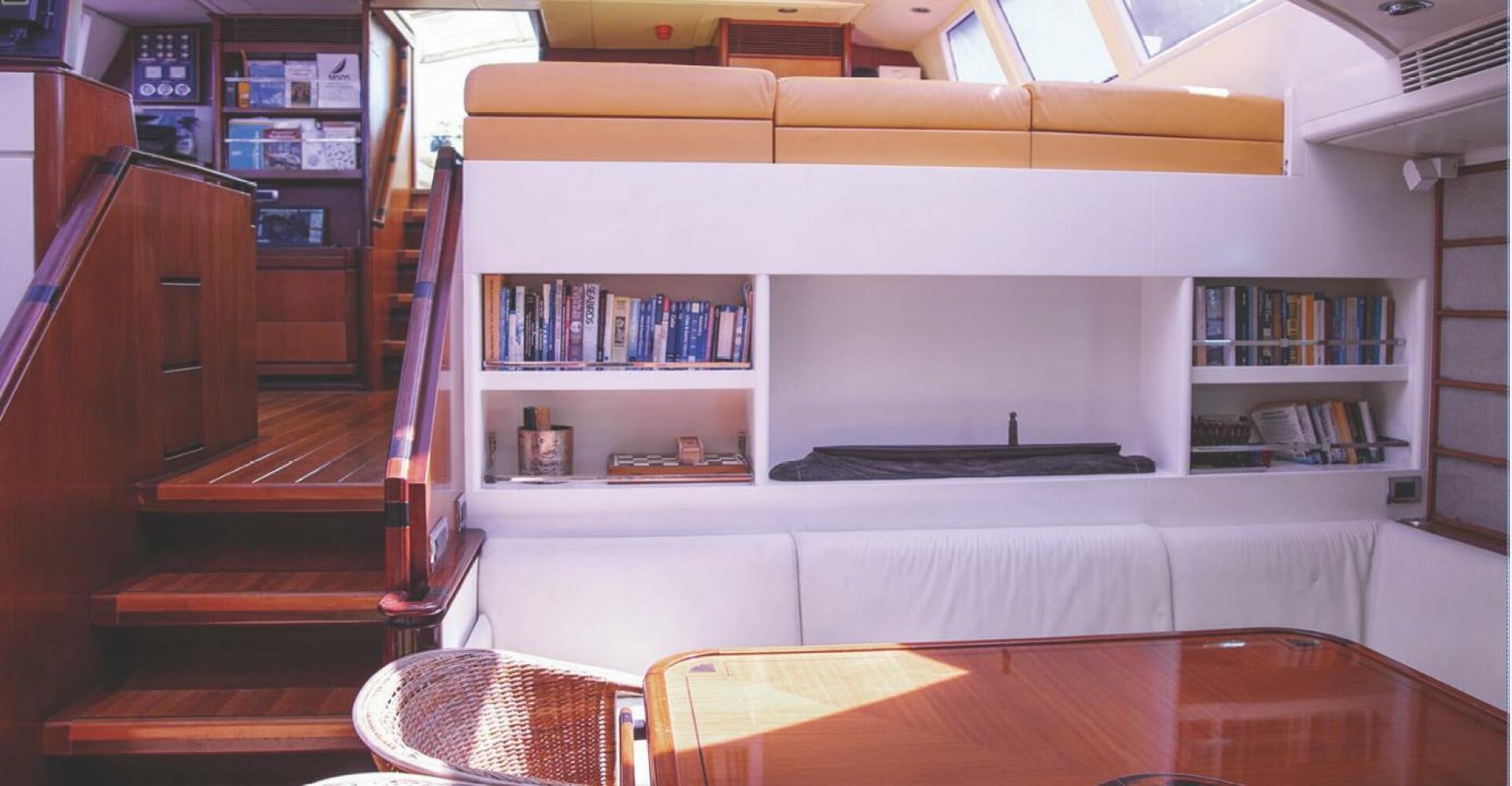 a room with a table and bookshelves aboard BILLY BUDD Yacht for Sale