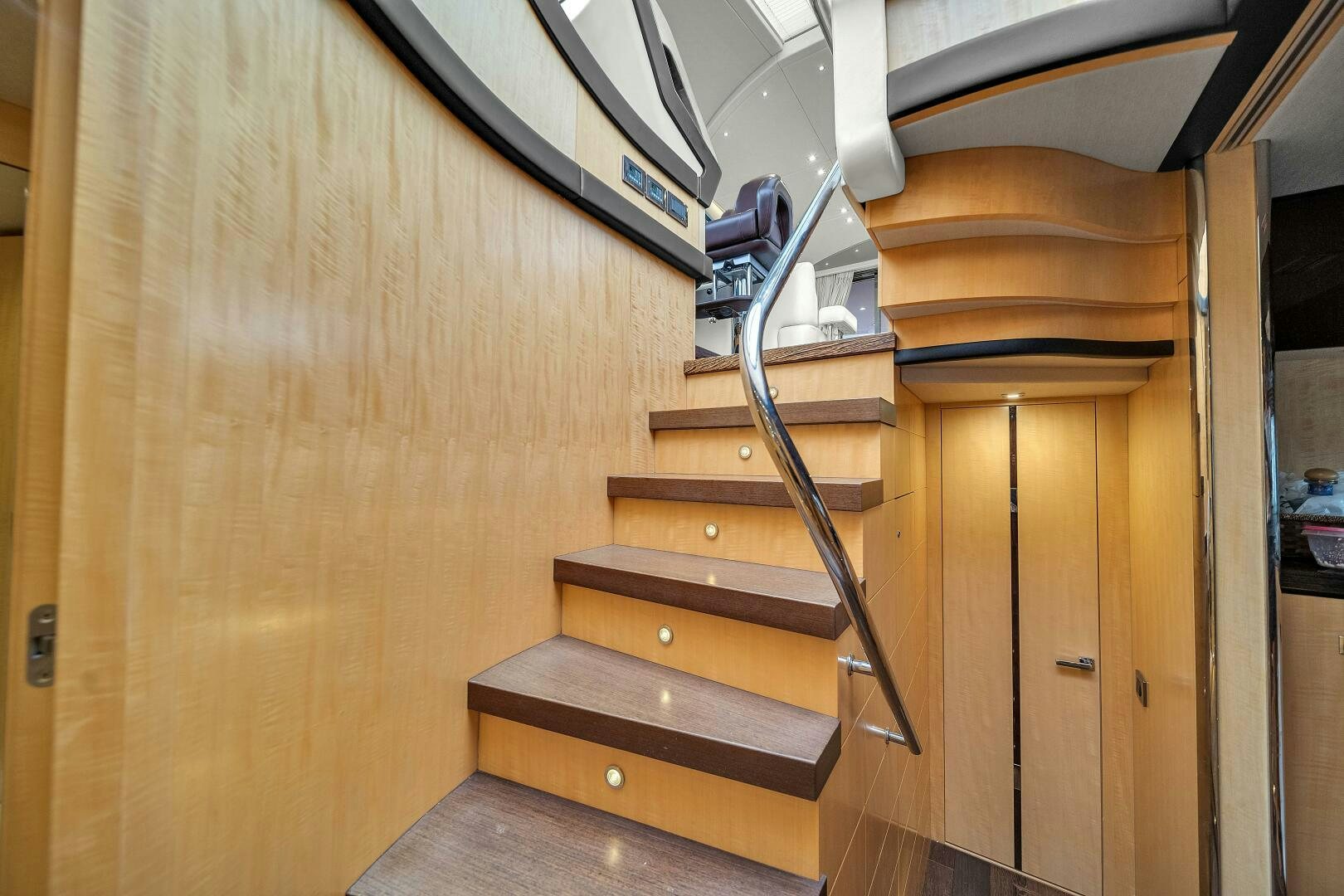 a wooden staircase with a metal railing aboard GEM Yacht for Sale