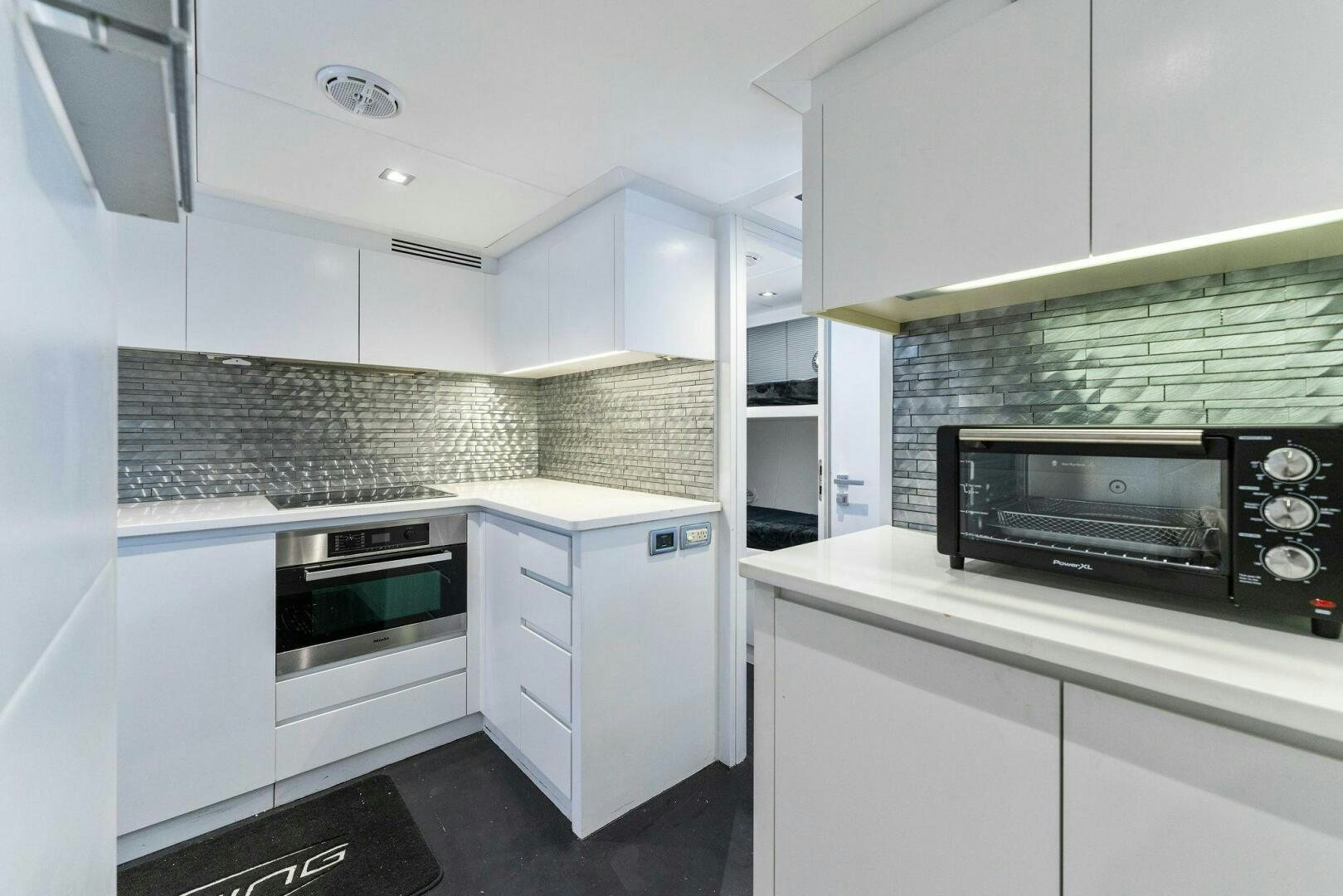 a kitchen with white cabinets aboard HAWK Yacht for Sale