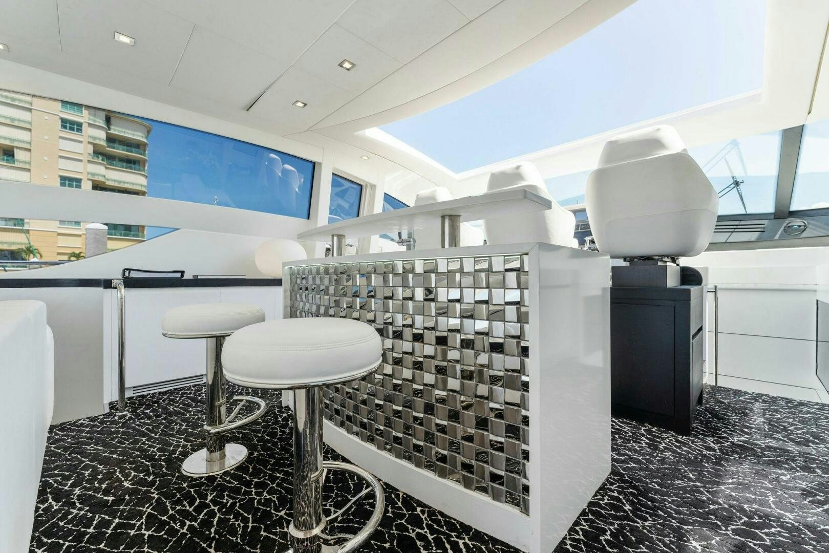 a room with a grill and stools aboard HAWK Yacht for Sale
