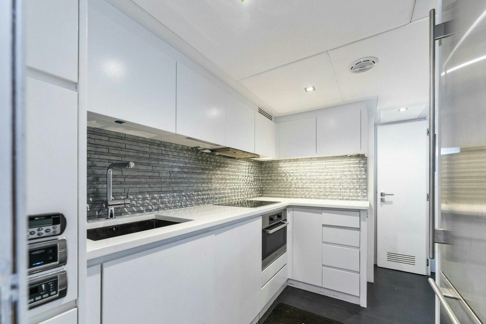 a kitchen with white cabinets aboard HAWK Yacht for Sale