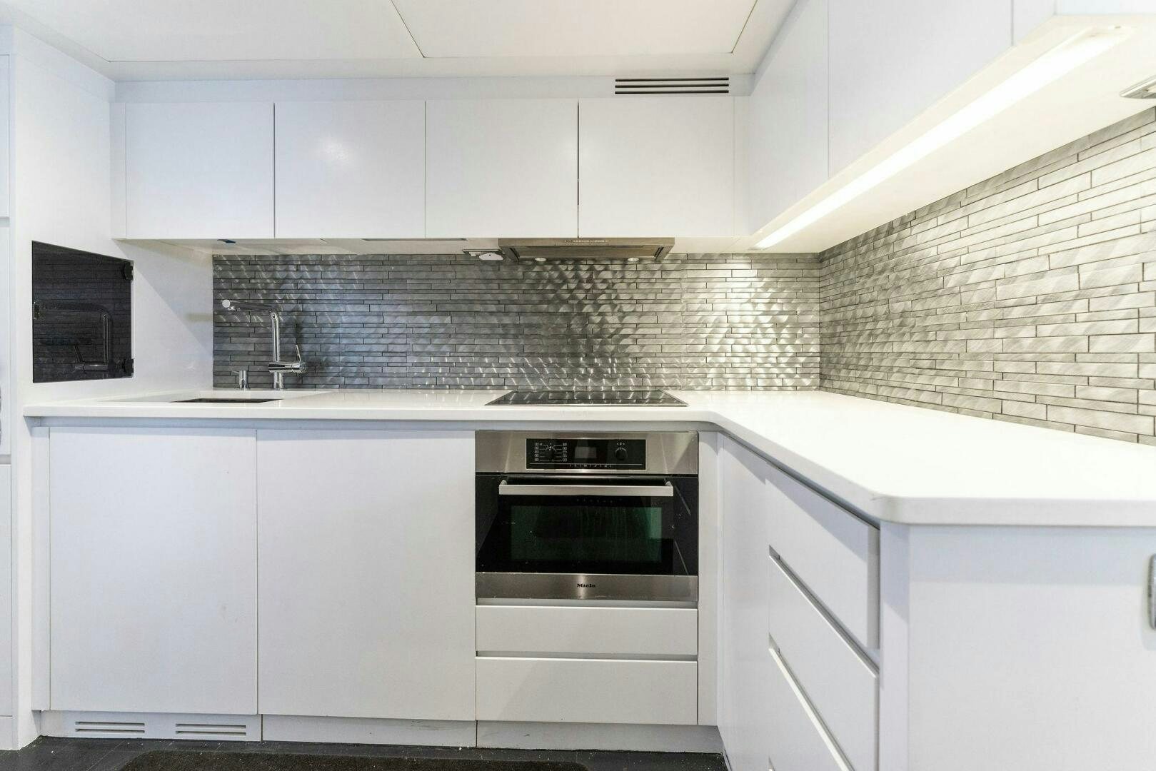 a kitchen with white cabinets aboard HAWK Yacht for Sale