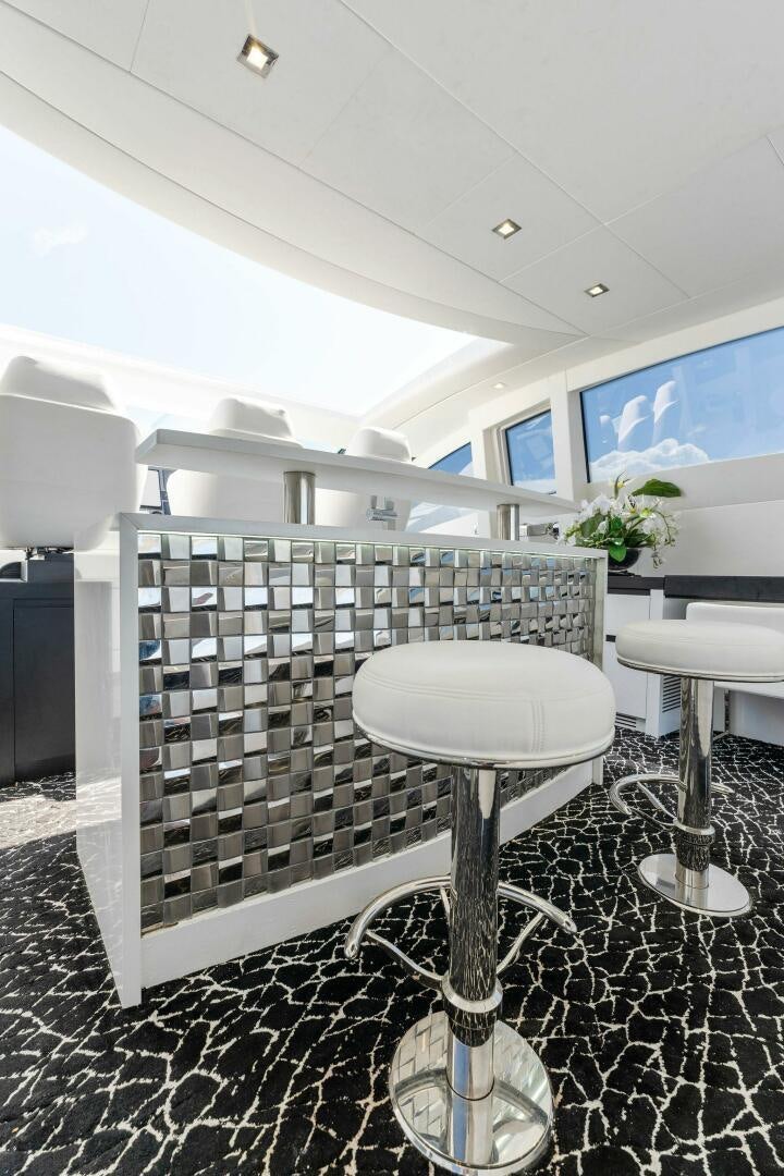 a room with a table and stools aboard HAWK Yacht for Sale