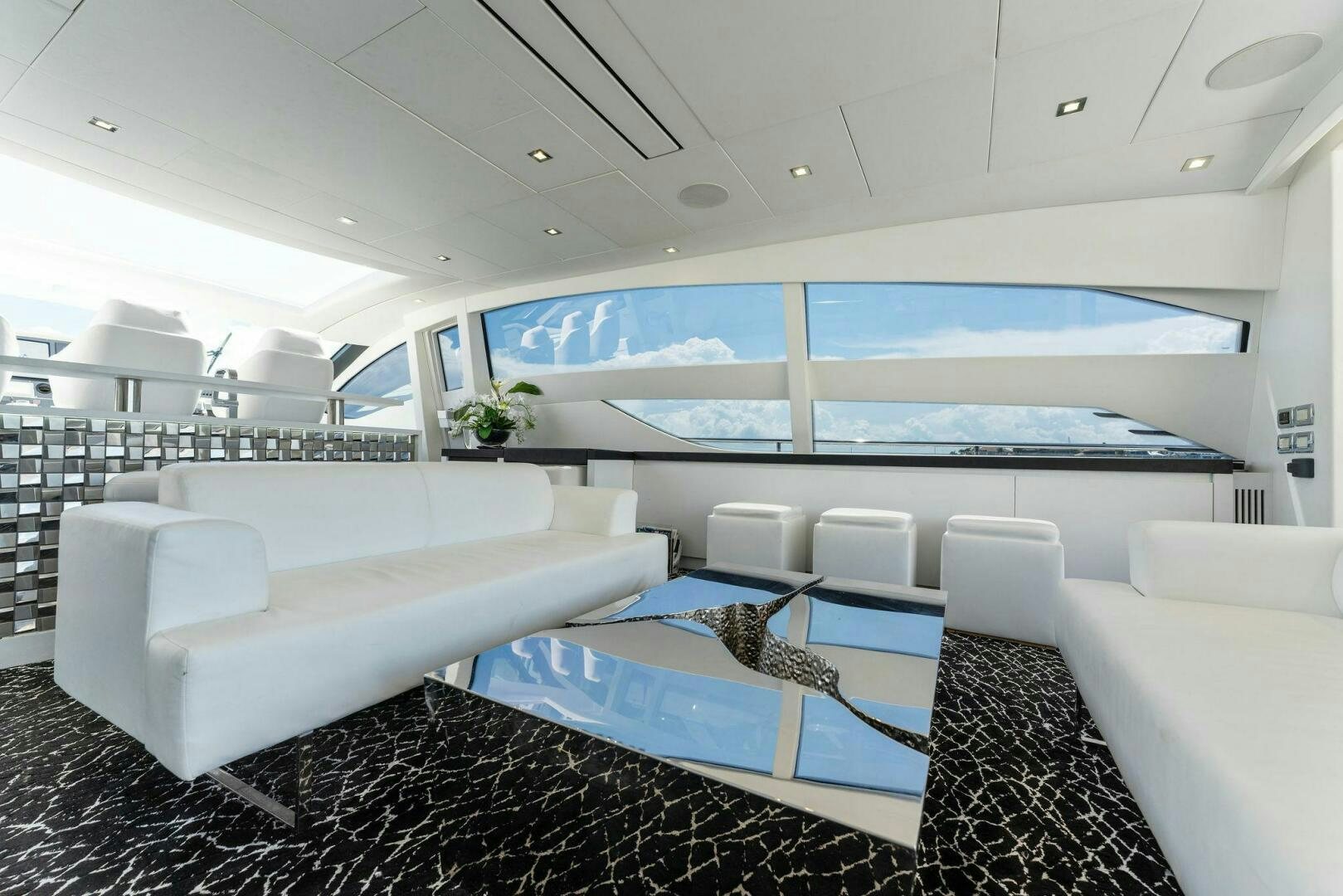a room with white couches and a large screen aboard HAWK Yacht for Sale