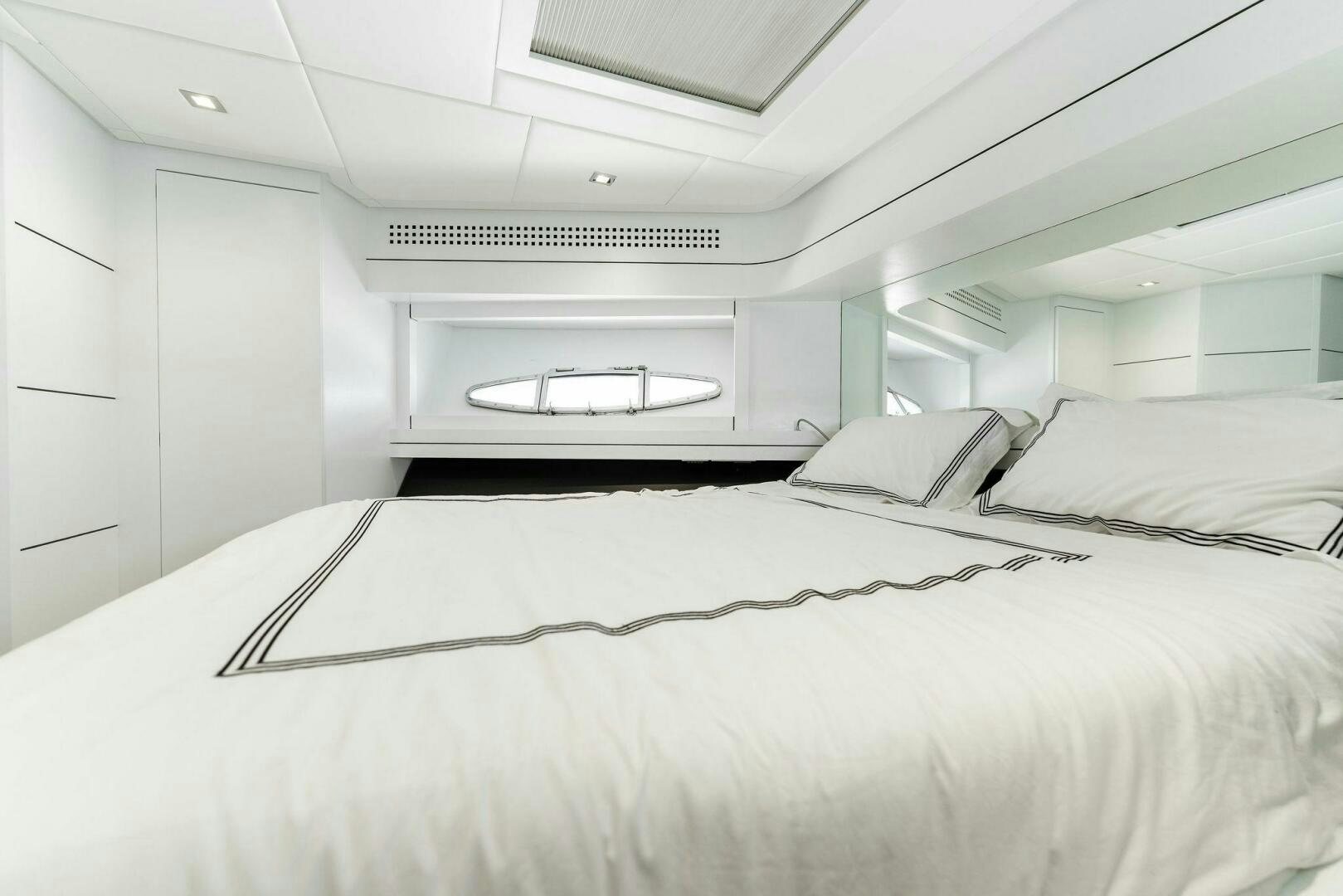 a white bedroom with a bed aboard HAWK Yacht for Sale
