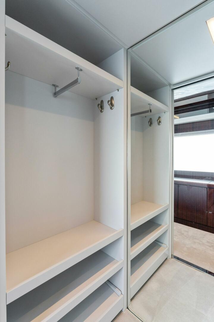 a white bunk bed with a white wall and wooden shelves aboard CHOP CHOP Yacht for Sale
