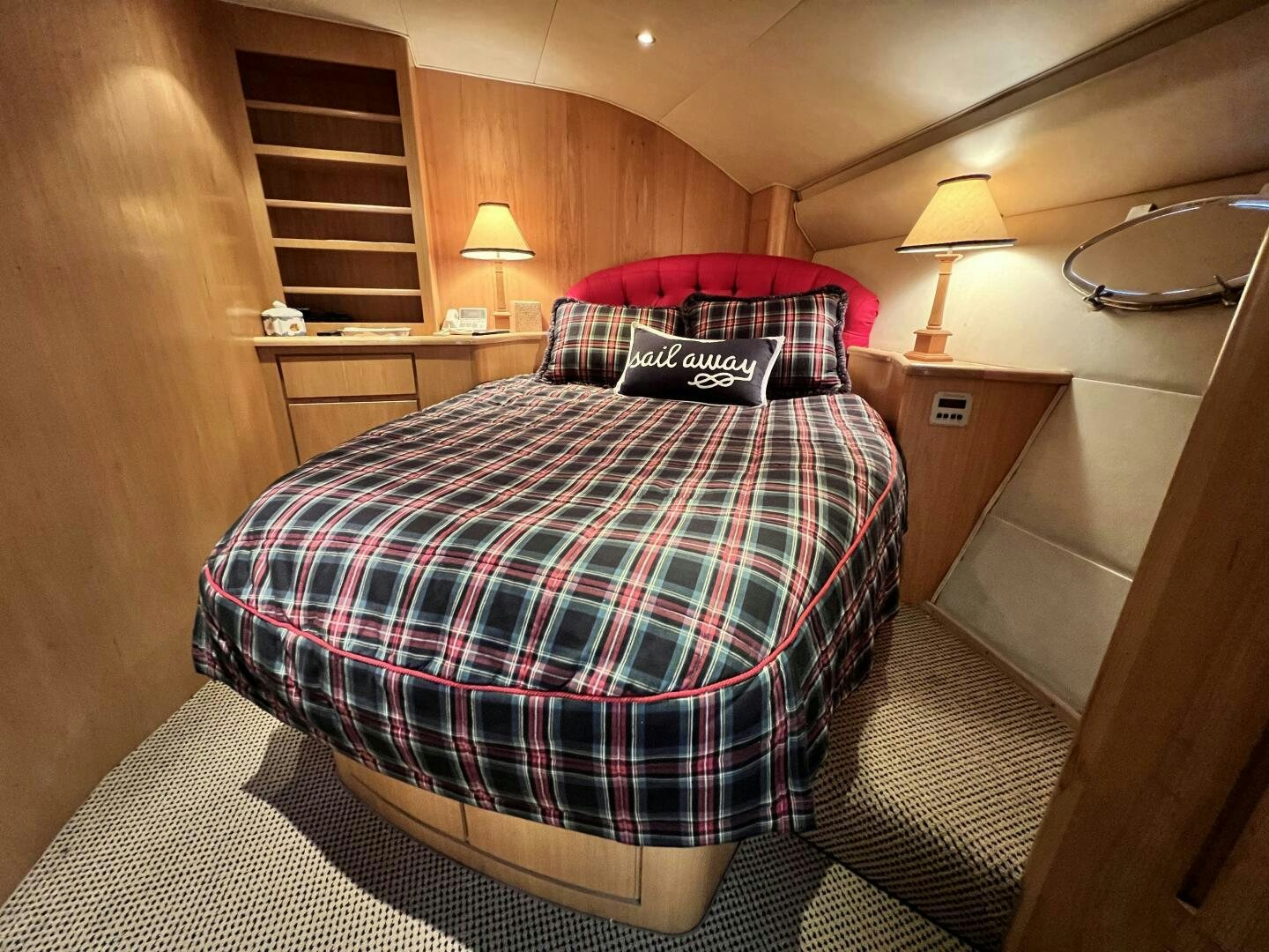 a bed with a red and black comforter and pillows aboard GOOD KARMA Yacht for Sale