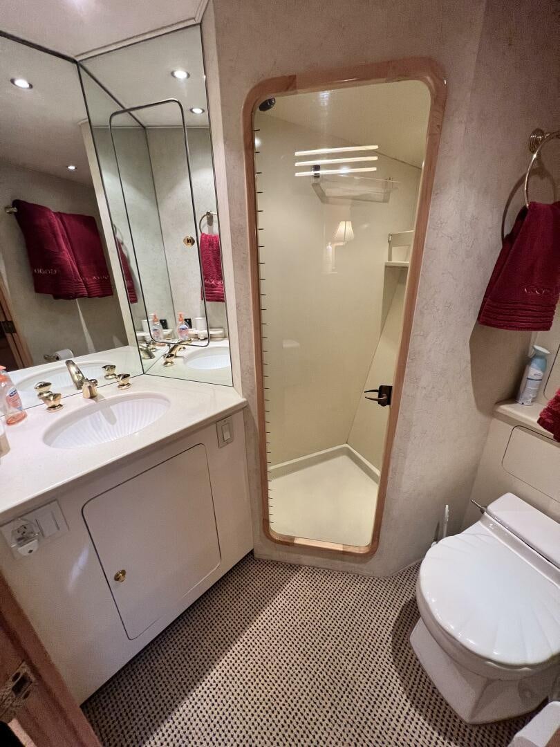 a bathroom with a glass shower door aboard GOOD KARMA Yacht for Sale