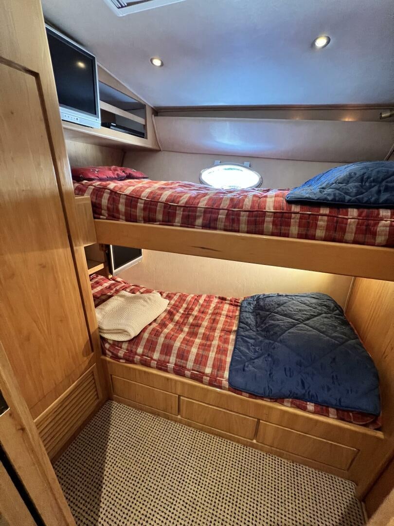 a bed with a television on the wall aboard GOOD KARMA Yacht for Sale