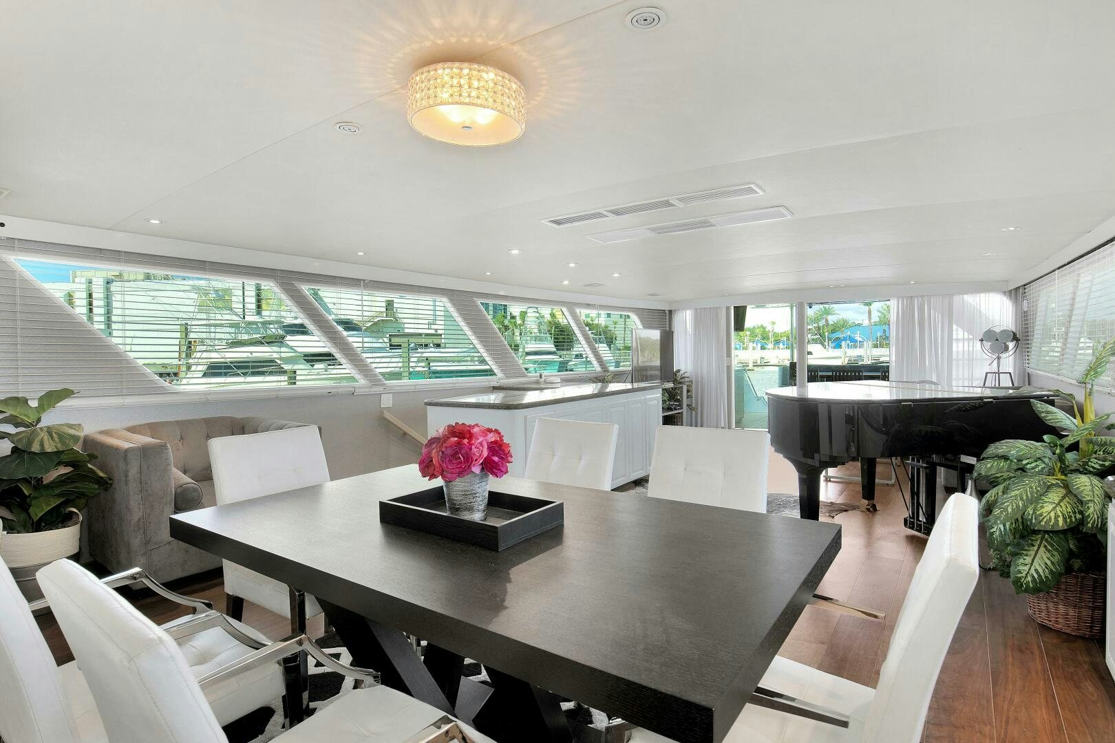 a room with a table chairs and plants aboard LADY P Yacht for Sale