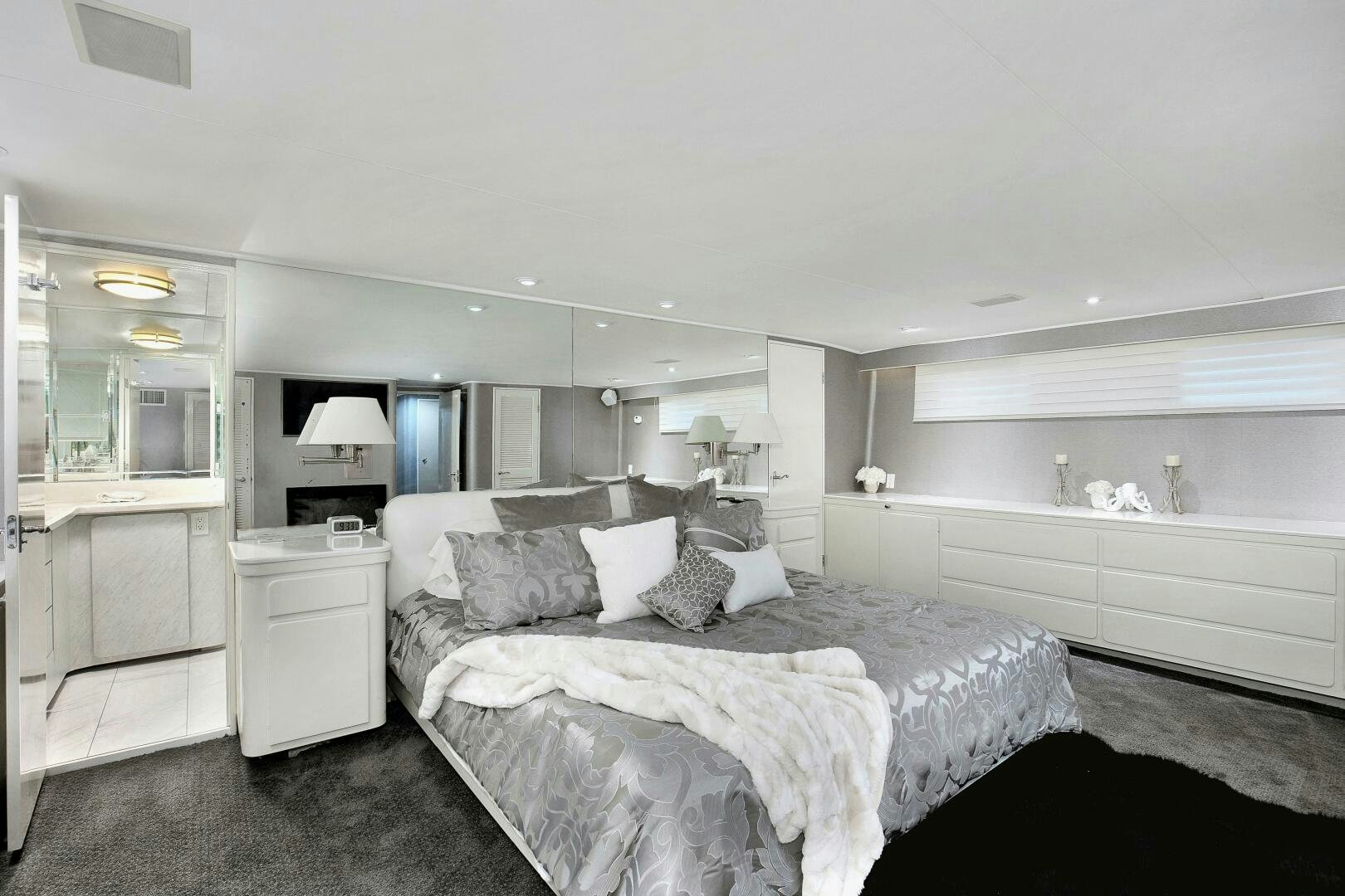 a bedroom with a bed and a dresser aboard LADY P Yacht for Sale
