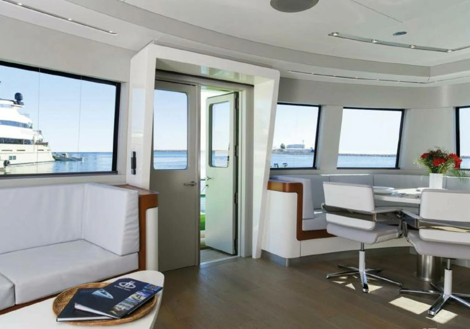 a room with a couch and a table and a window aboard NAVCAT Yacht for Sale