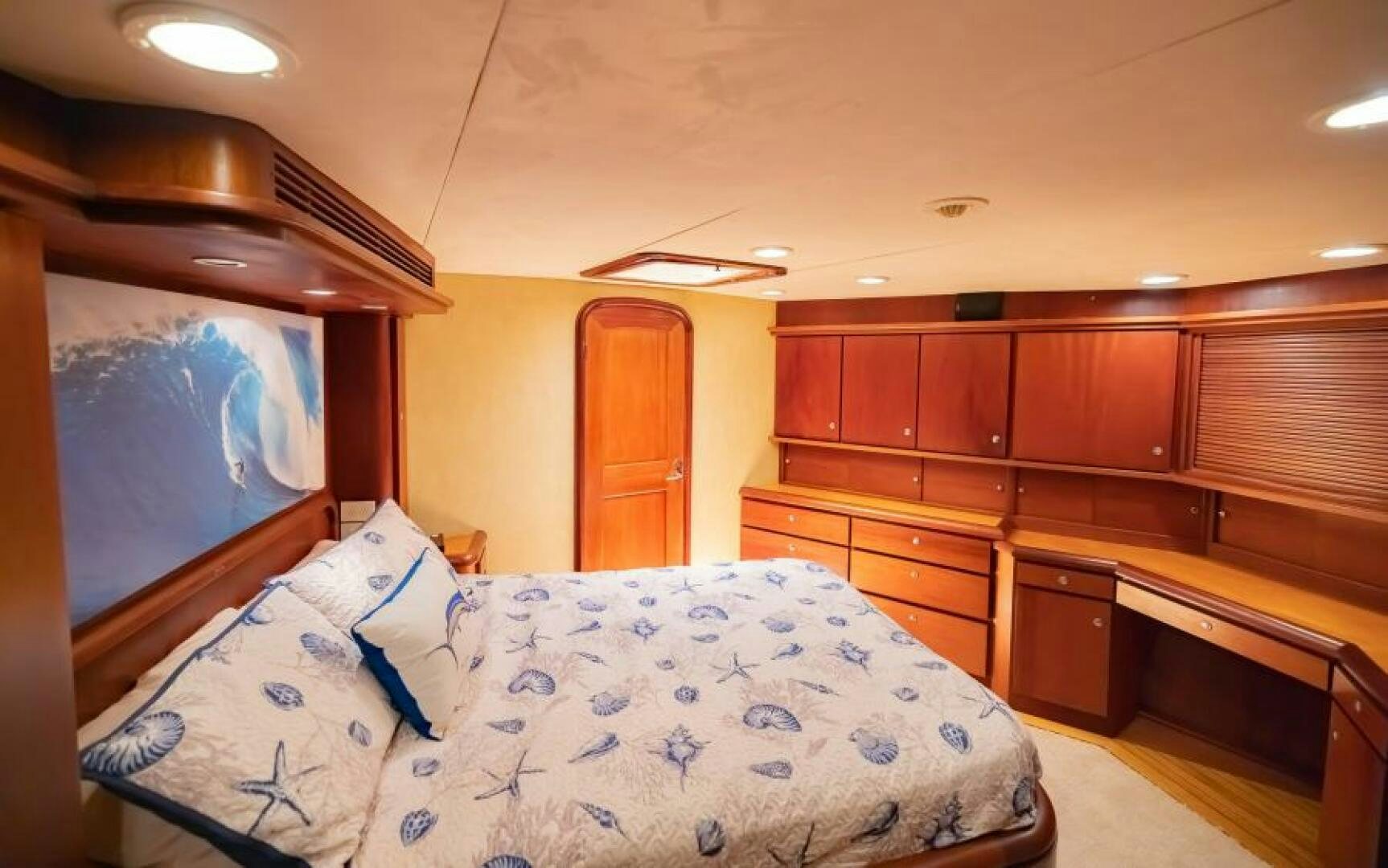 a bedroom with a bed and a dresser aboard BOOMER Yacht for Sale