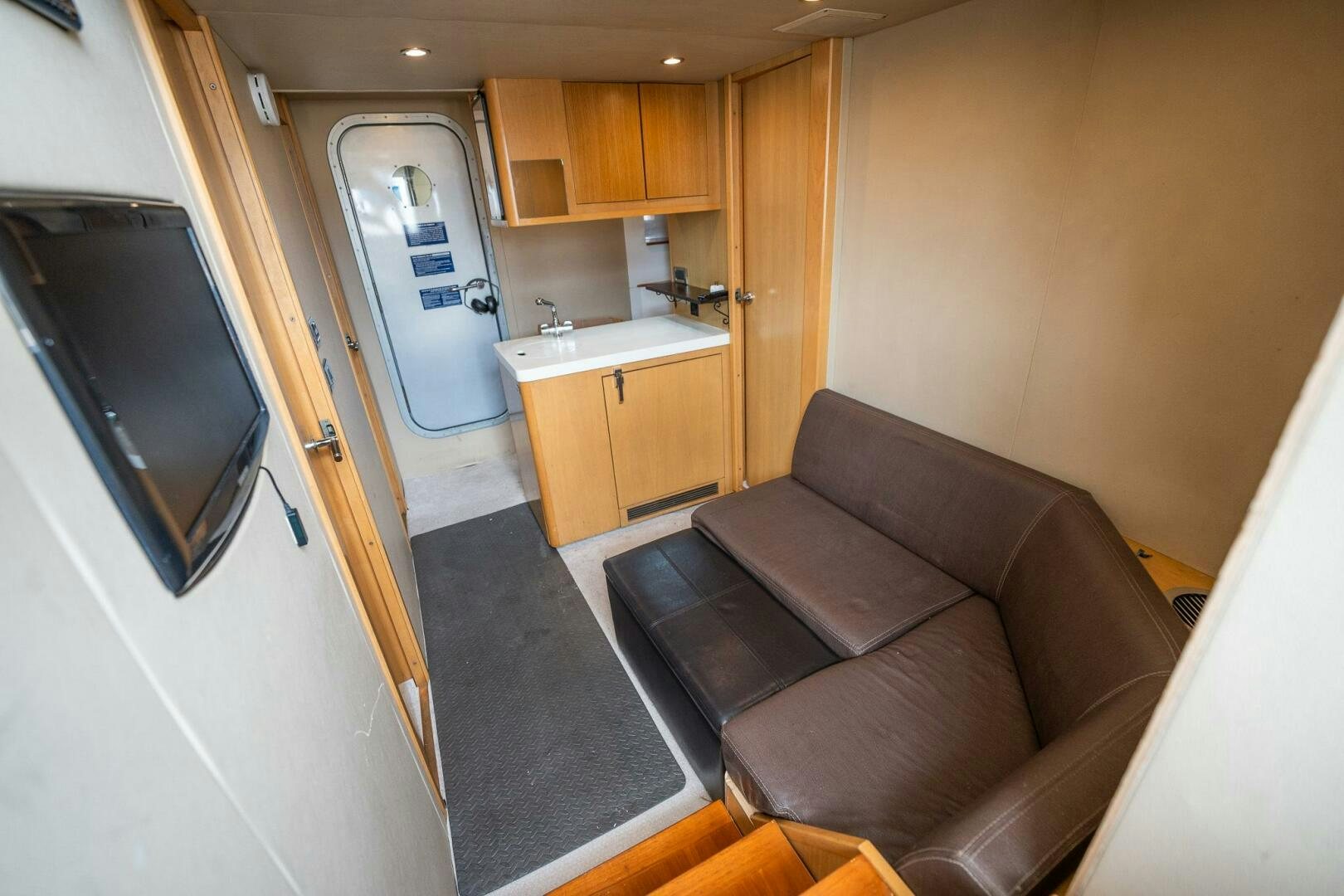 a living room with a couch and a television aboard NO CURFEW Yacht for Sale