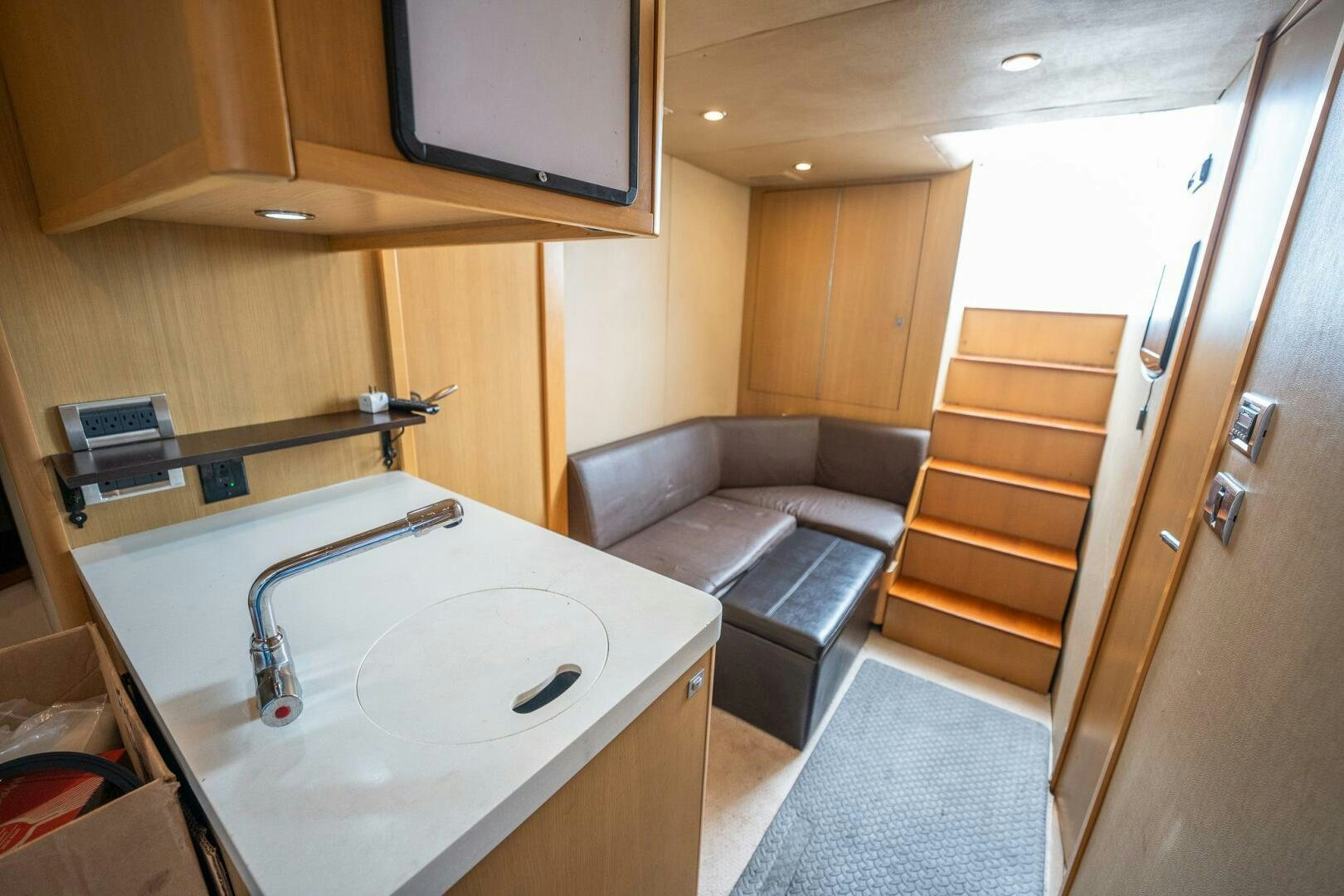 a small bathroom with a couch and a sink aboard NO CURFEW Yacht for Sale