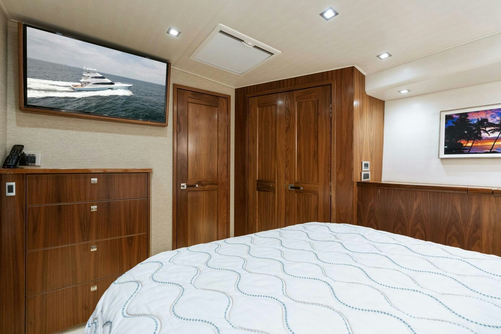 a bedroom with a bed and wooden cabinets aboard SOLONIAN Yacht for Sale