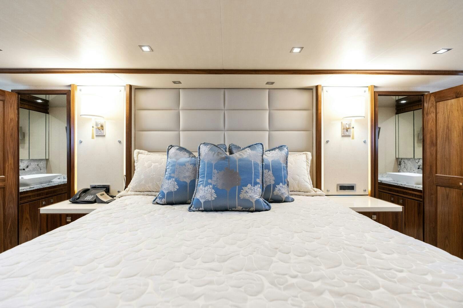 a bed with a white sheet and blue pillows aboard SOLONIAN Yacht for Sale