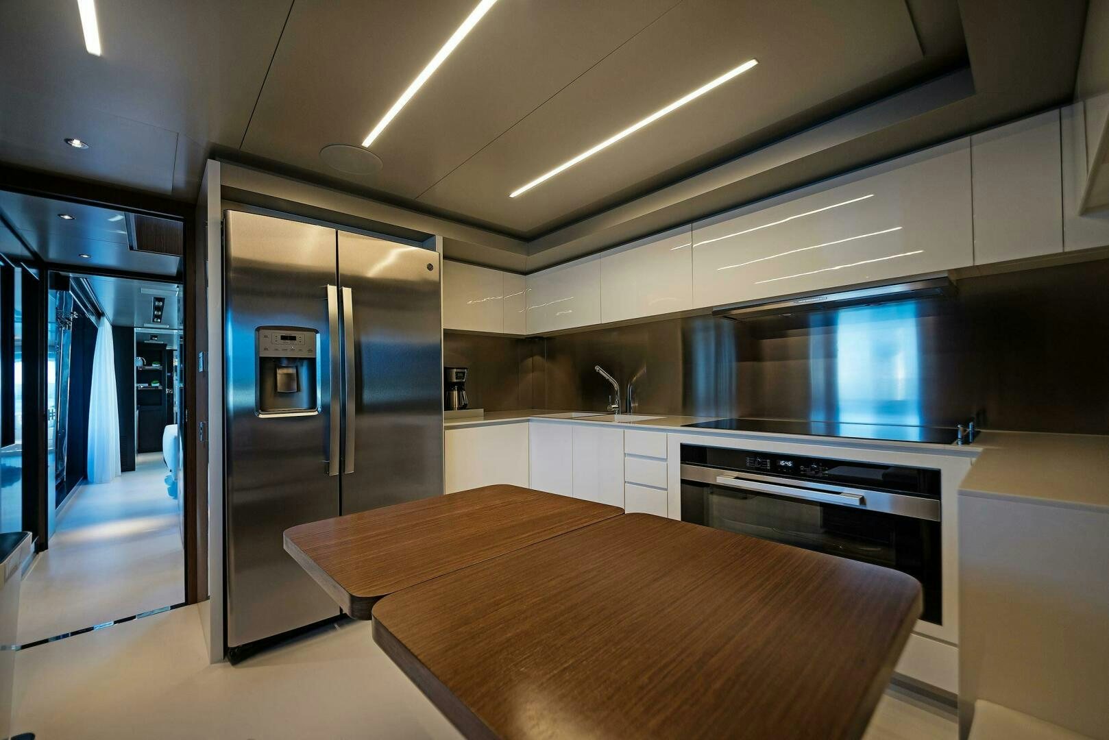a kitchen with a refrigerator and a table aboard ALEGRA Yacht for Sale