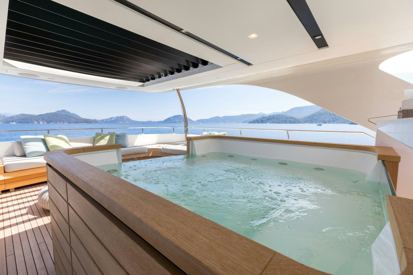 a pool with a deck and a view of mountains and water aboard GLORY Yacht for Sale