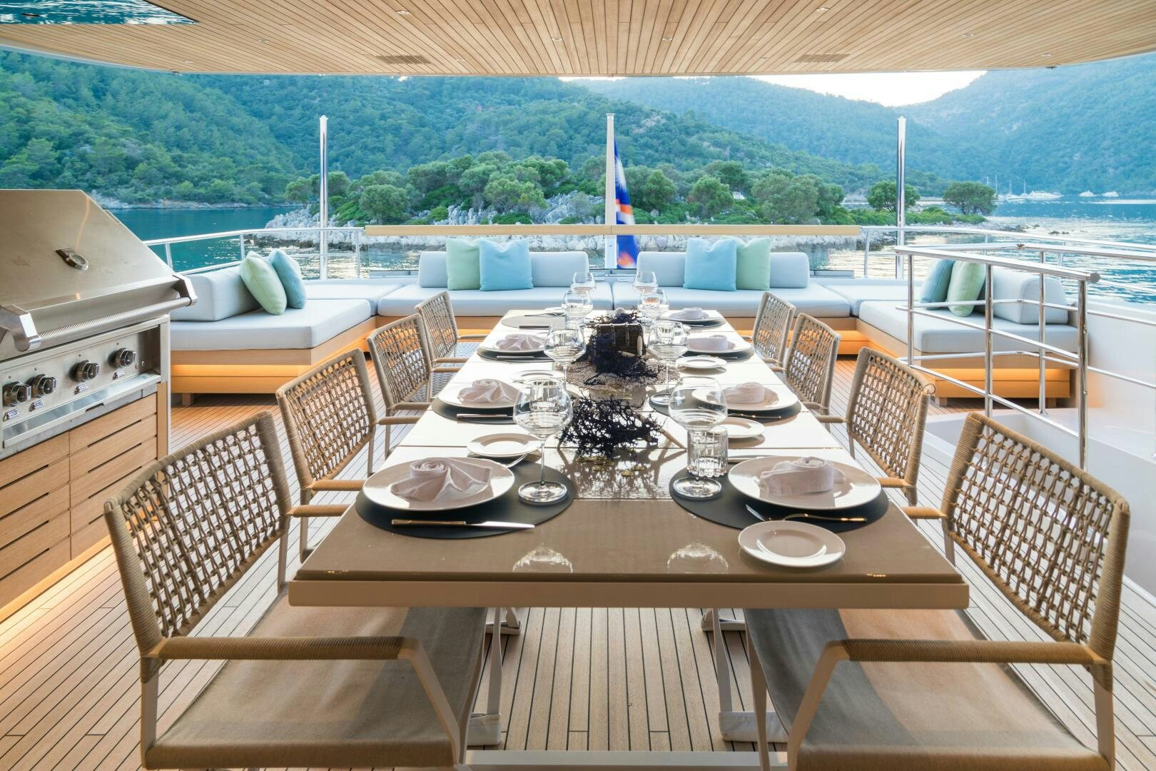 a table set for a meal on a deck overlooking a body of water aboard GLORY Yacht for Sale