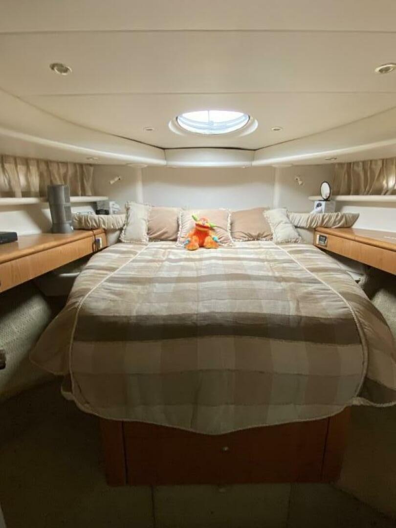 a bed with a blue and white comforter and pillows aboard BIGG FIGG II Yacht for Sale