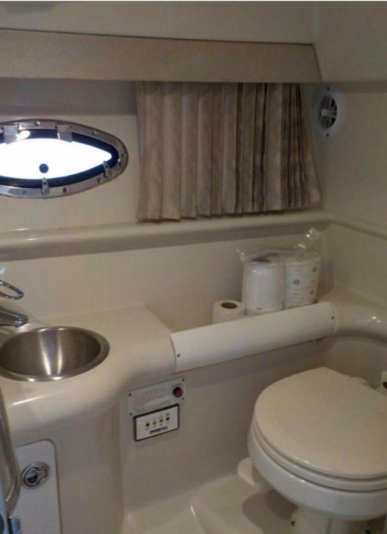a bathroom with a toilet and a sink aboard SERENITY NOW Yacht for Sale